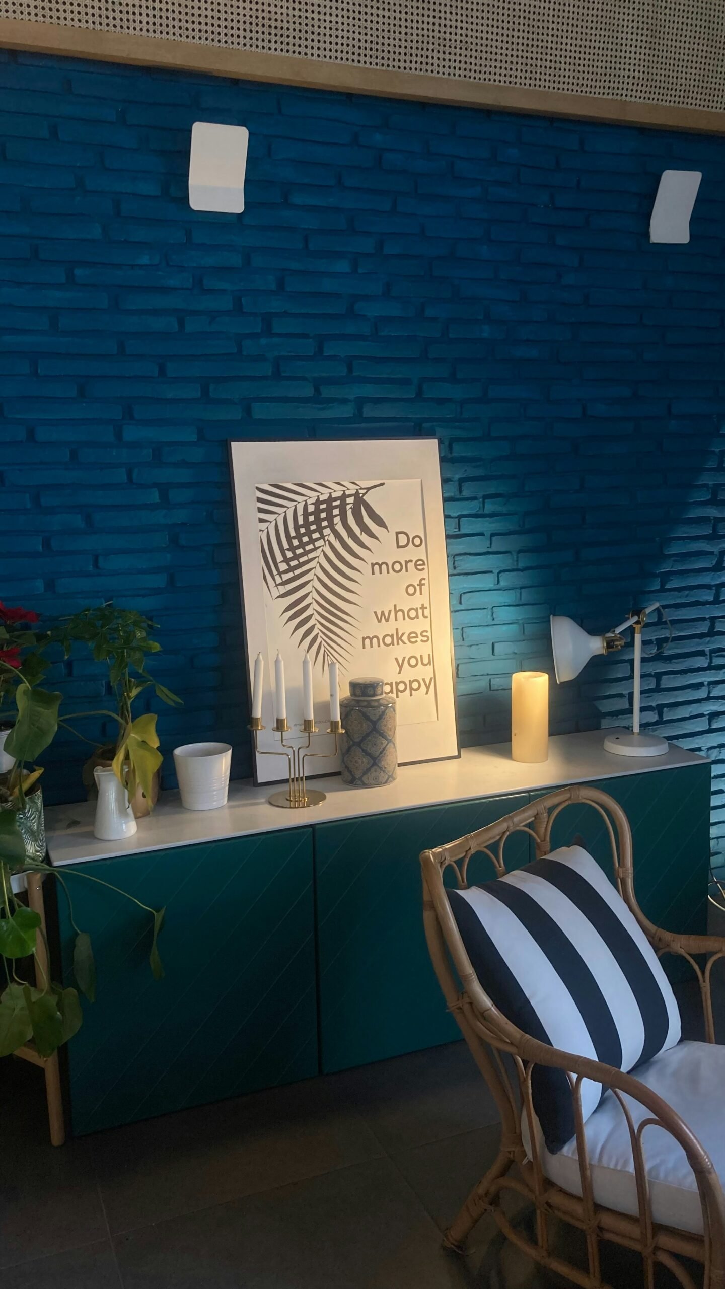 a room with a blue brick wall and a wicker chair